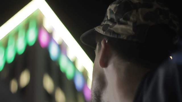 Face Of A Man Against The Background Of A Glowing Building Close-up