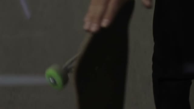 Man Twists A Skateboard Close-up