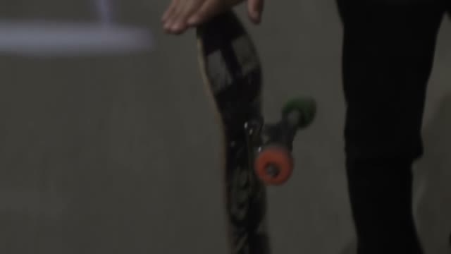 Young Man Twists A Skateboard Close-up