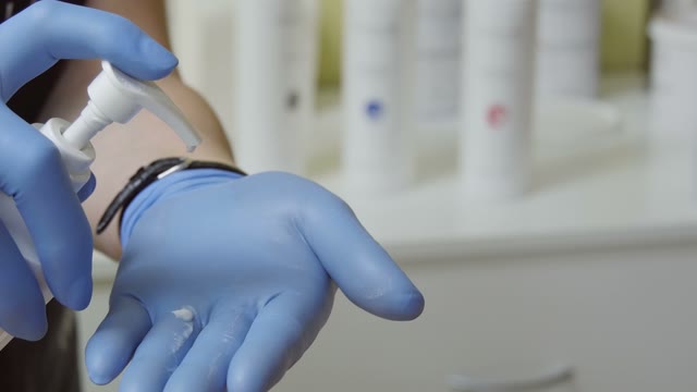 Woman In Rubber Gloves Holds A Cream In Her Hand