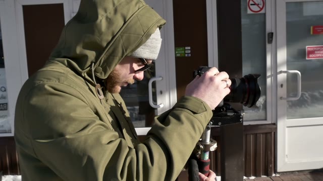 Guy Adjusts The Camera And Shoots