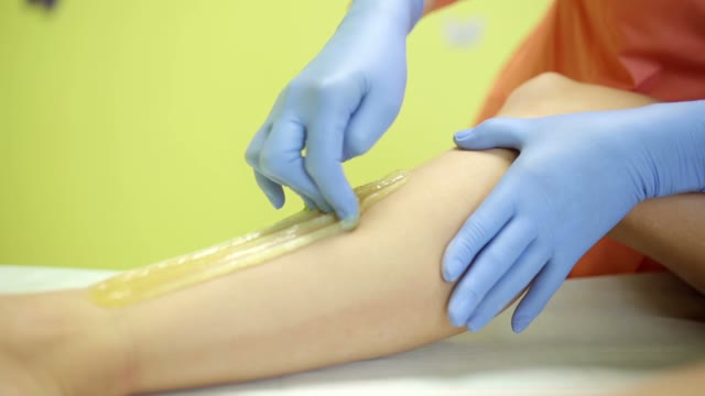 Woman In Blue Gloves Performs A Shugaring Procedure