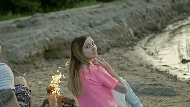 Girl Sits On The Shore And Turns Around