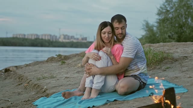 Guy Hugs The Girl And Looks At The Bonfire