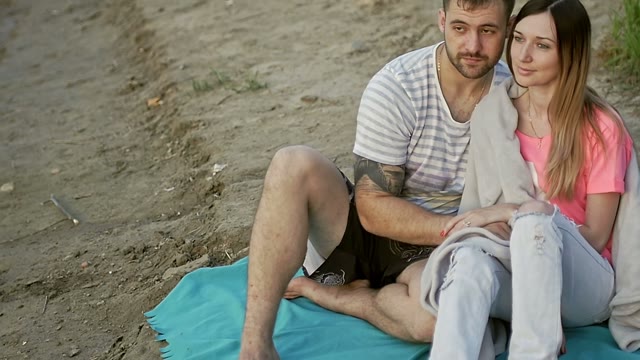 Girl With A Guy Is Sitting On A Sandy Beach
