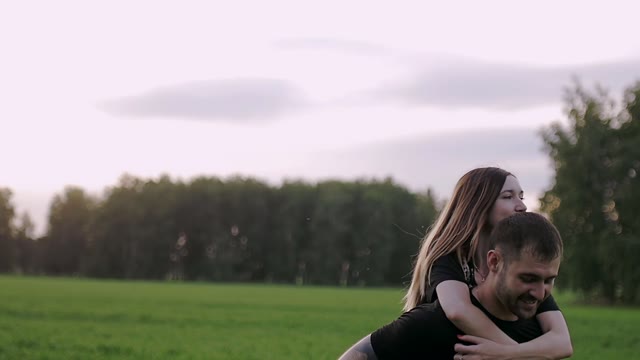 Girl Ride On The Back Of Her Boyfriend In The Field