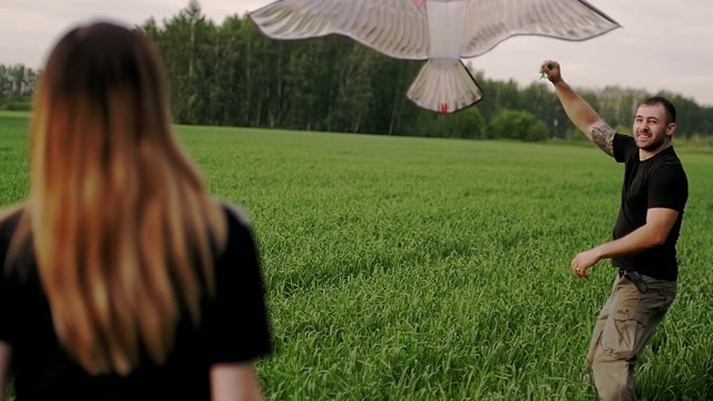 Man Lifts A Kite Into The Air And Runs