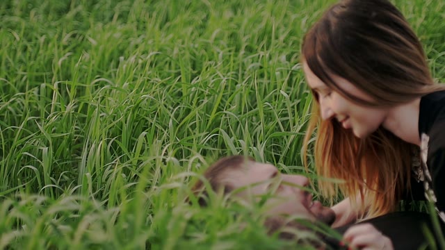Young Couple Lies On The Gound And Looks At Each Other