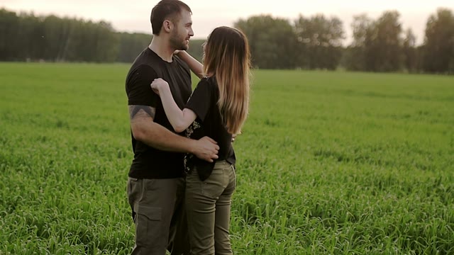 Guy With A Girl Is Standing In The Field And Hugs