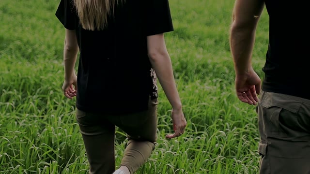Guy With The Girl Walking Along The Field Together