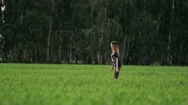 Girl Is Walking Along The Green Field