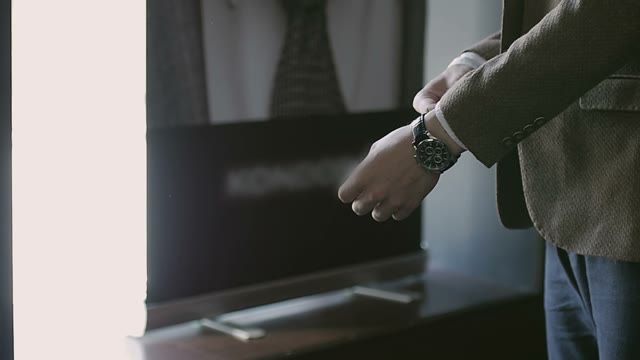 Man In A Jacket Fastens His Watch On His Arm
