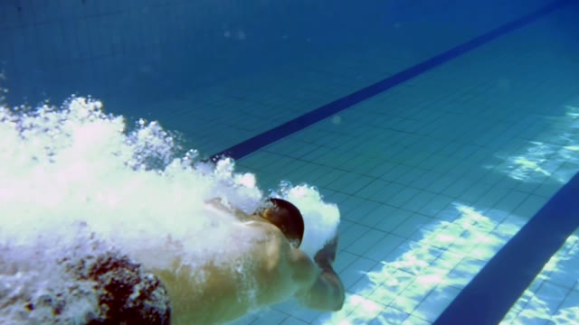 Man Is Swimming Under The Water In The Pool
