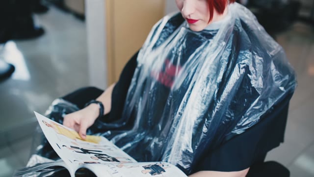 Girl Is Sitting In A Chair And Watching Magazines