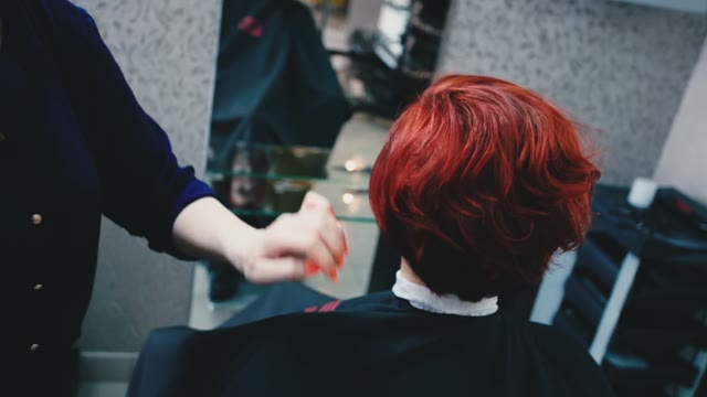 Hairdresser Sprinkles Spray On The Client's Hair