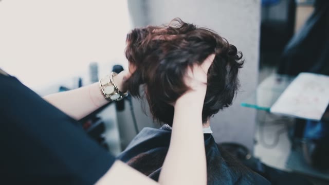 Hairdresser Ruffles The Client's Hair On The Back Of The Head