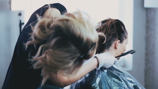 Colorist Levels The Client's Hair At The Back Of The Head