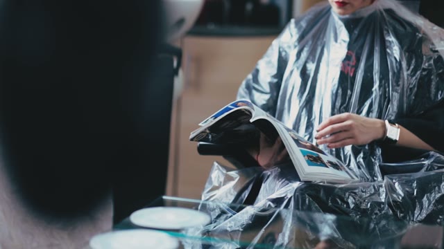 Girl Sits In A Chair And Leaf Through Magazines