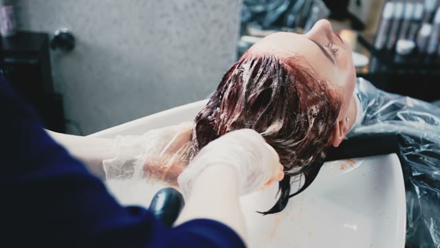 Woman In Gloves Washes Hair A Client In Fashion Salon