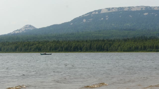 Man Rowing Oars In A Boat In The Lake