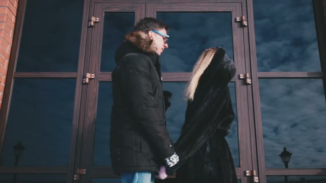 Guy With The Girl Is Standing At The Door Of The Building