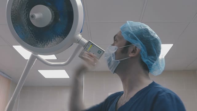 Doctor Tilts The Lamp And Looks At The Patient